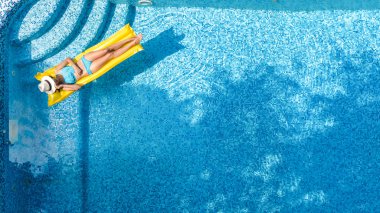 Güzel genç kız rahatlatıcı yüzme havuzunda şişme yatak üzerinde yüzüyor ve aile tatil tropikal tatil, hava uçak görünümü yukarıdan su eğlence var