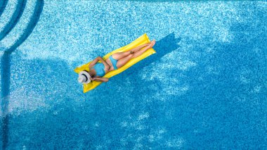 Güzel genç kız rahatlatıcı yüzme havuzunda şişme yatak üzerinde yüzüyor ve aile tatil tropikal tatil, hava uçak görünümü yukarıdan su eğlence var
