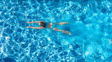 Yüzme havuzundaki aktif kız yukarıdan drone görüntüsü, mavi suda yüzen genç kadın, tropikal tatil, tatil konseptinde tatil