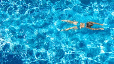 Yüzme havuzundaki aktif kız yukarıdan drone görüntüsü, mavi suda yüzen genç kadın, tropikal tatil, tatil konseptinde tatil