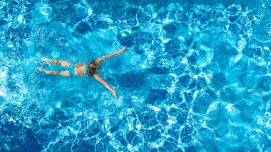 Yüzme havuzundaki aktif kız yukarıdan drone görüntüsü, mavi suda yüzen genç kadın, tropikal tatil, tatil konseptinde tatil