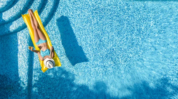 スイミング プールでリラックスした美しい若い女の子の膨脹可能なマットレスの上を泳ぐし 水の楽しみは 家族での休暇 熱帯リゾート地で上から空中ドローン ビュー — ストック写真
