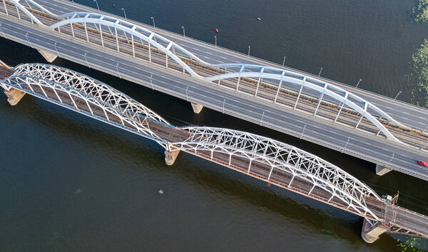 Aerial top view of automobile and railroad Darnitsky bridge across Dnieper river from above, Kiev (Kyiv) city skyline, Ukraine