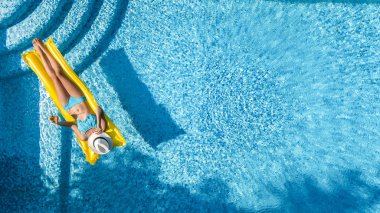 Güzel genç kız rahatlatıcı yüzme havuzunda şişme yatak üzerinde yüzüyor ve aile tatil tropikal tatil, hava uçak görünümü yukarıdan su eğlence var