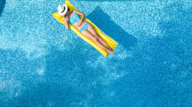 Güzel genç kız rahatlatıcı yüzme havuzunda şişme yatak üzerinde yüzüyor ve aile tatil tropikal tatil, hava uçak görünümü yukarıdan su eğlence var