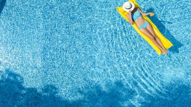 Güzel genç kız rahatlatıcı yüzme havuzunda şişme yatak üzerinde yüzüyor ve aile tatil tropikal tatil, hava uçak görünümü yukarıdan su eğlence var