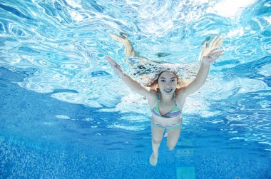Çocuk yüzme havuzunda su altında yüzüyor, mutlu aktif genç kız dalıyor ve su altında eğleniyor, çocuk fitness ve tatil beldesinde aile tatilinde spor yapıyor.