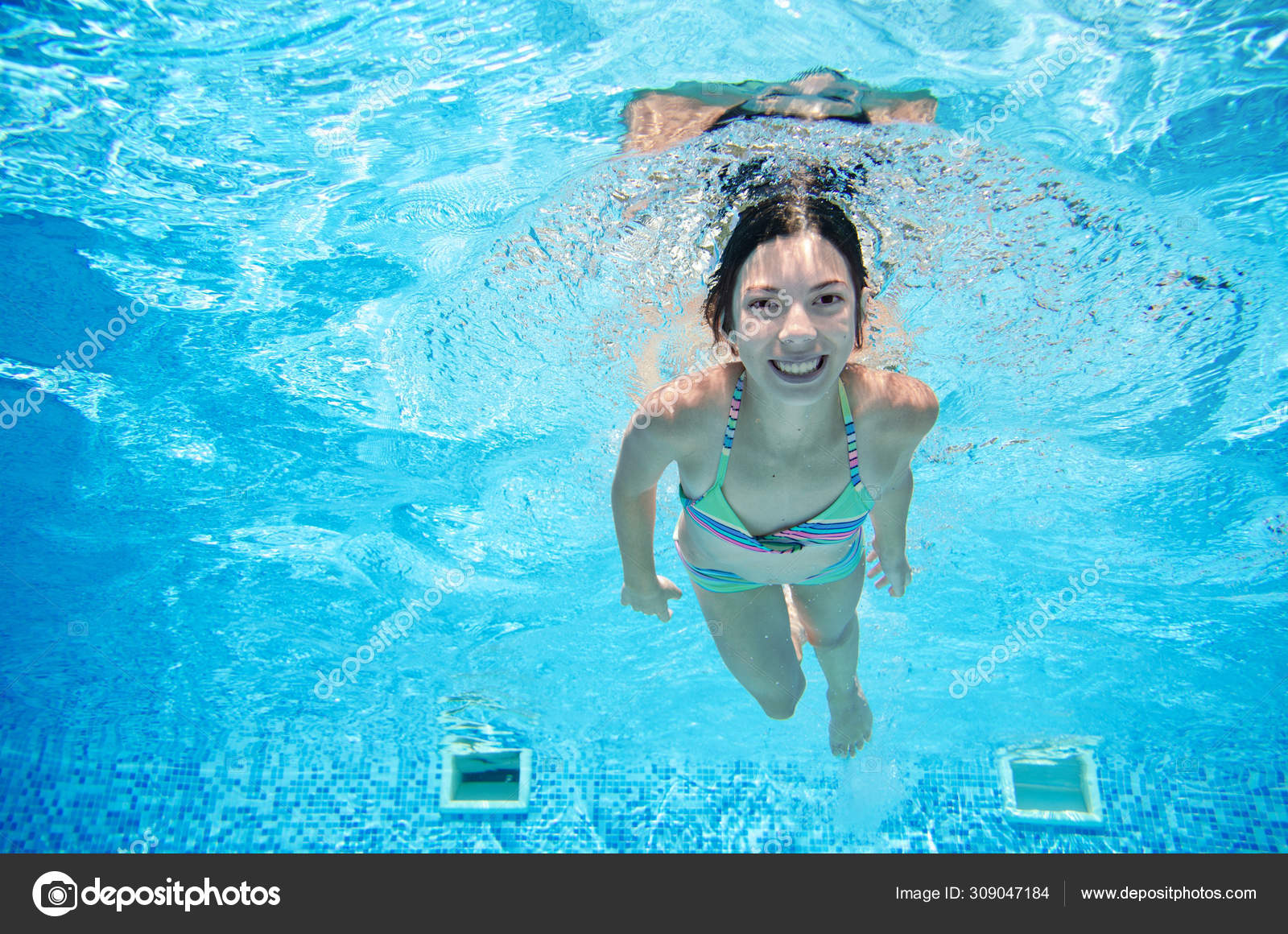 Ребенок плавает под водой в бассейне, счастливая активная девочка-подросток...