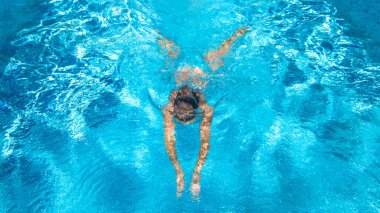 Yüzme havuzundaki aktif kız yukarıdan drone görüntüsü, mavi suda yüzen genç kadın, tropikal tatil, tatil konseptinde tatil