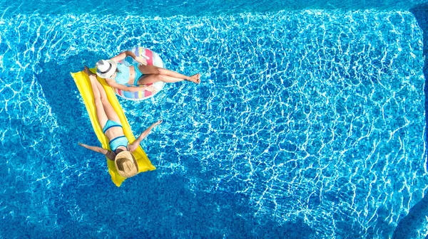 孩子们在游泳池的空中俯瞰着天上的雾气 快乐的孩子们在充气的环形甜甜圈和床垫上游泳 活跃的女孩们在度假度假时享受着水中的乐趣 — 图库照片
