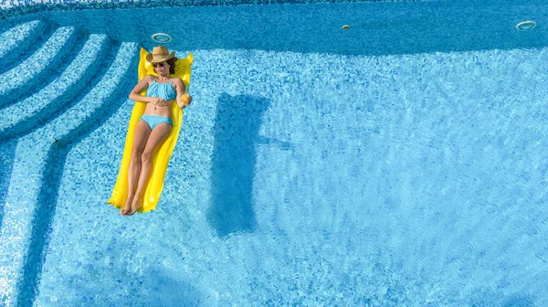 아름다운 수영장에서 휴식을 취하고 여자가 푹신푹신 매트리스를 수영을 물에서 재미를 — 스톡 사진