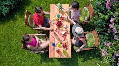 Aile ve arkadaşlar yaz bahçe partisinde dışarıda birlikte yemek yiyorlar. Yukarıdan yiyecek ve içeceklerle dolu bir masa manzarası. Tatil, tatil ve piknik konsepti.