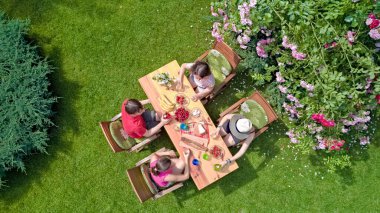 Aile ve arkadaşlar yaz bahçe partisinde dışarıda birlikte yemek yiyorlar. Yukarıdan yiyecek ve içeceklerle dolu bir masa manzarası. Tatil, tatil ve piknik konsepti.