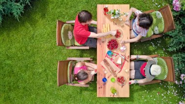 Aile ve arkadaşlar yaz bahçe partisinde dışarıda birlikte yemek yiyorlar. Yukarıdan yiyecek ve içeceklerle dolu bir masa manzarası. Tatil, tatil ve piknik konsepti.