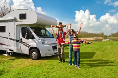 Aile tatili, çocuklarla karavan gezisi, çocuklu mutlu ebeveynler karavanda tatilde eğlenmek, karavan gezisi.