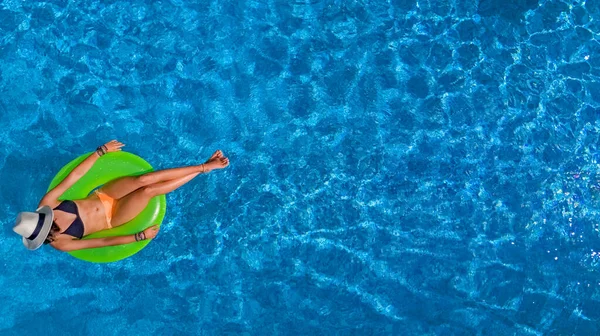 在游泳池空中俯瞰美丽的女帽女郎 穿着比基尼的少女在充气环甜甜圈上放松和游泳 度假时在水里玩得很开心 — 图库照片