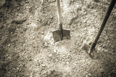 Taze toprak ve iki kürek. Umutlarınızı, hayallerinizi, hislerinizi gömün. Kapalı tonlar, vignet, kopyalama alanı.