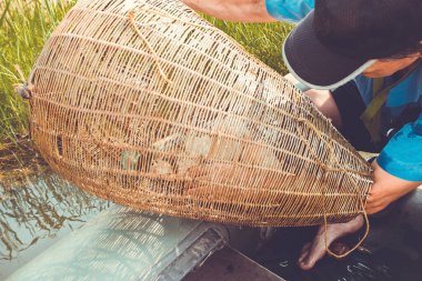 Balıkçı oltası, top, lastik bir teknede balıkçı. Bir göl, bir nehir, güneşli bir yaz günü. Erkek eller tuzağı kontrol etsin. Vintage tonlama, gün ışığı.