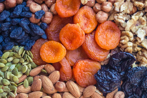 Abundance, an assortment of useful food. The source of vegetable protein, microelements and vitamins. Orange, black, green and brown colors. Daylight.