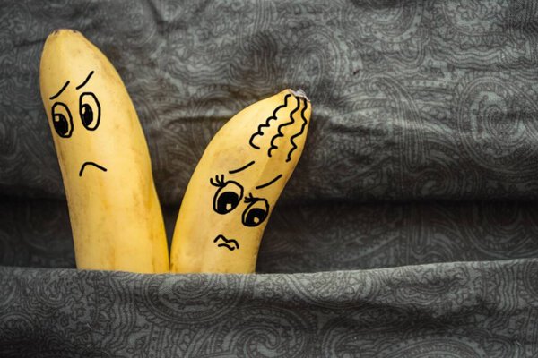 In bed, on the dark sheets, two bananas, a husband and wife. Tiff, resentment, resentment partner. The picture is made by the author.