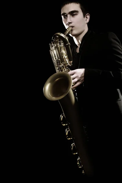 Saxophone player Jazz musician. Saxophonist playing jazz music. Baritone sax player isolated on black closeup