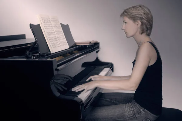 Piano player. Pianist woman playing piano. Classical musician closeup with grand piano