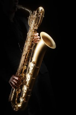 Saksafon çalar saksofoncu oynarken caz müzik. Bariton saksafon çalar üzerinde siyah eller izole