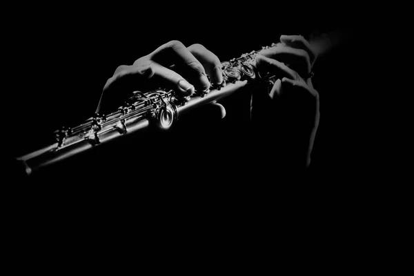 Flute instrument. Flutist hands playing flute music. Player with orchestra instrument closeup. Flute isolated on black