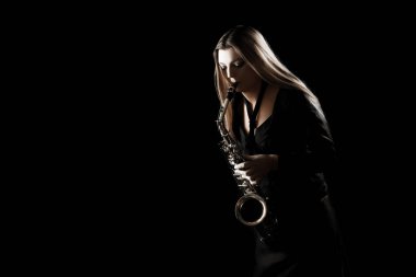 Saksafon çalar. Caz müzisyeni saksofoncu kadın siyah izole sax oyuncunun oynadığı