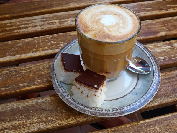 一杯新鲜的卡布奇诺咖啡拿铁与椰子蛋糕一起供应 — 图库照片
