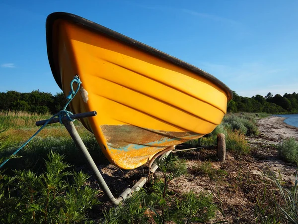 Small dingy boat on a trailer standing by the sea ocean shore and ready for action - boating sailing background image