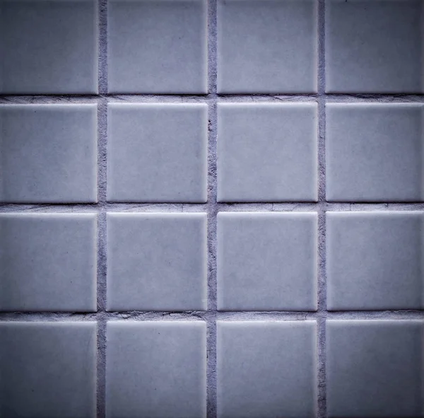 gray tiled wall close-up texture with vignette. background, interior.