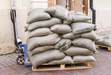 yükleyici ile ahşap palet üzerinde inşaat çantaları. Endüstriyel, bina.