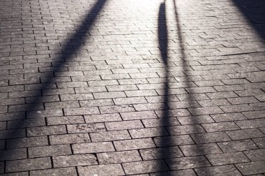 bakış açısı ile fayans döşeli kaldırım üzerinde güneş gölgeler. arka plan, aydınlatma.