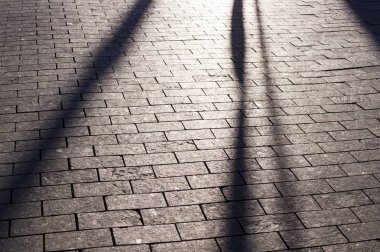 bakış açısı ile fayans döşeli kaldırım üzerinde güneş gölgeler. arka plan, aydınlatma.