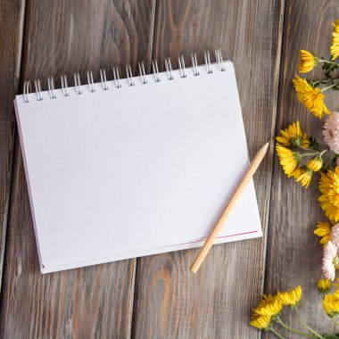 Sonbahar parlak arka plan. Yazıt için Not defteri. Çiçekler, yapraklar kahverengi ahşap arka plan üzerinde. Sonbaharda tatiller ve Şükran günü için arka plan.