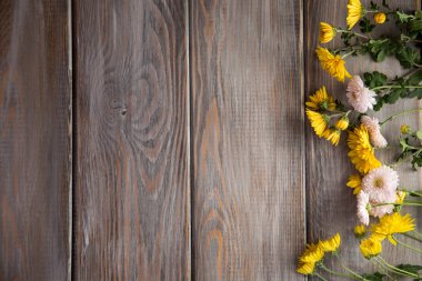 Sonbahar arka plan. Kahverengi ahşap arka plan üzerinde çiçekler. Yazıt için bir yer. Sonbaharda tatiller ve Şükran günü için arka plan.