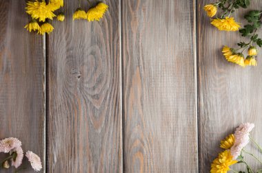 Sonbahar arka plan. Kahverengi ahşap arka plan üzerinde çiçekler. Yazıt için bir yer. Sonbaharda tatiller ve Şükran günü için arka plan.