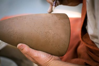 Seramik Atölyesi, asıl unfired hamurlu sürahi otnament koyar. Ana eller Close-up. El ile yapılan bir hobi. Kil ile manuel çalışma gösteren arka plan.
