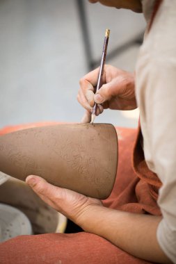 Seramik Atölyesi, asıl unfired hamurlu sürahi otnament koyar. Ana eller Close-up. El ile yapılan bir hobi. Kil ile manuel çalışma gösteren arka plan.