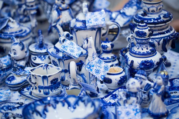 Fair with dishes and souvenirs in Russian traditional style. Traditional colors are blue and white. Gzhel - Russian folk craft from ceramics and porcelain production. Close-up.