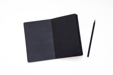 Defter ile siyah kağıt ve kalem beyaz arka plan üzerinde. İşyeri sanatçı veya yazar. üstten görünüm. yakın çekim, mockup.