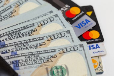 Bişkek, Kırgızistan - 17 Şubat 2019: Siyah m-cüzdan, yüz dolar faturaları ve kredi kartı visa ve master card kopya alanı beyaz zemin üzerine.