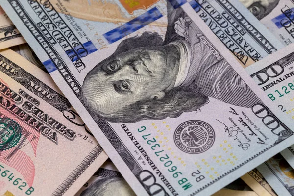 Background of dollar bills. American Dollars Cash Money. One hundred dollars, fifty dollars, ten dollars Banknotes. Benjamin Franklin\'s portrait