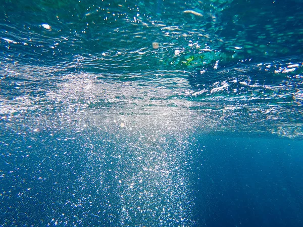 Pęcherzyki powietrza pod wodą wzrosnąć. Piękna tekstura morza i wody oceanu. Lotnicze niebieskie tło. Fotografia podwodna. — Zdjęcie stockowe