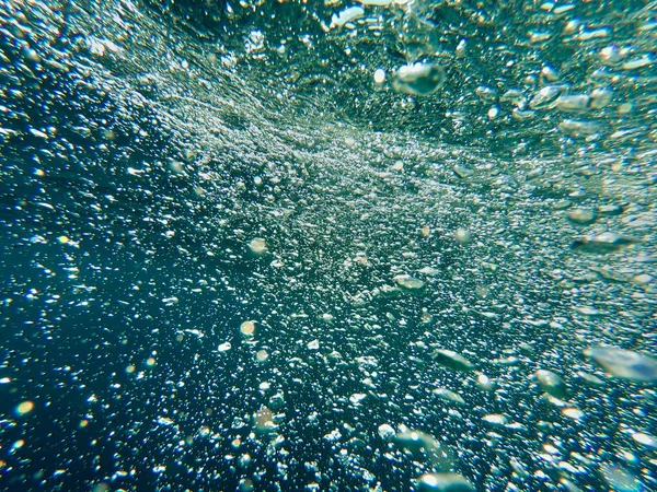 As bolhas de ar sob a água sobem. Bela textura de mar e água do oceano. Fundo azul aéreo. Fotografia subaquática . — Fotografia de Stock