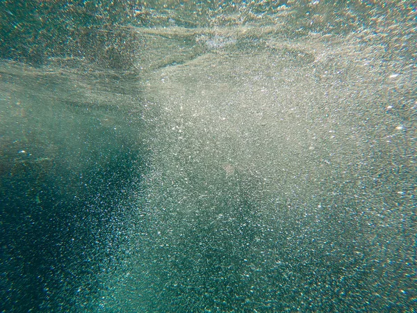 Air bubbles under the water rise up. Beautiful texture of sea and ocean water. Aerial blue background. Underwater photography. — Stock Photo, Image