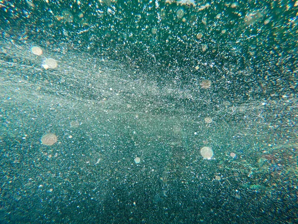 Air bubbles under the water rise up. Beautiful texture of sea and ocean water. Aerial blue background. Underwater photography. — Stock Photo, Image