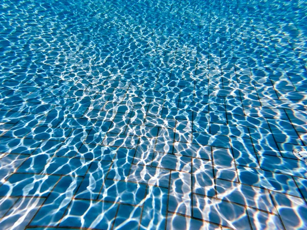 Água clara transparente na piscina. Foto subaquática da piscina reguladora. Fundo fundo da piscina de água azul. Tema de verão . — Fotografia de Stock