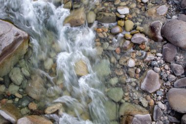 Azgın nehirdeki su. Taşların ve suyun güzel doğal arka planı. Berrak su ve hızlı nehir dokusu. Metin eklemek için arka plan. Turizm ve seyahat.